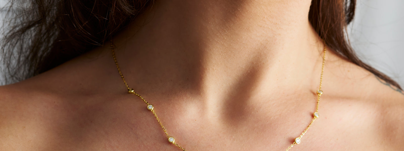 Fine moissanite station necklace worn at the collarbone