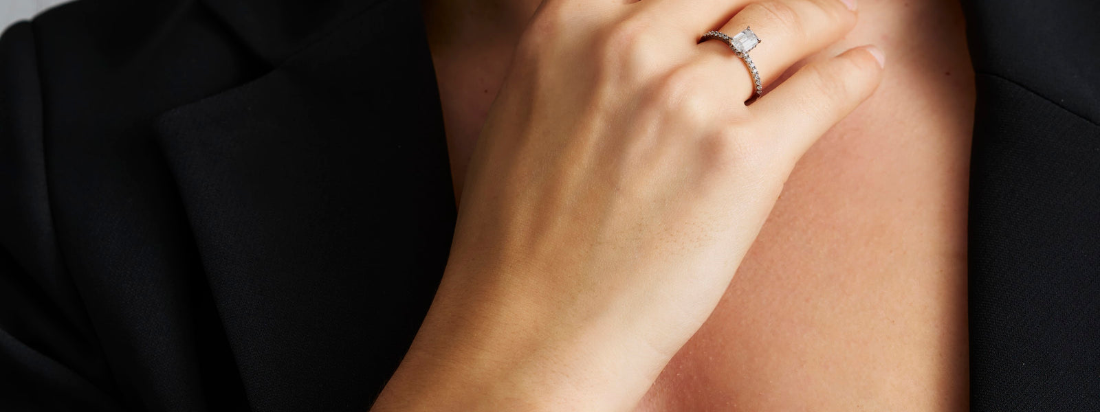 Emerald cut moissanite engagement ring worn on the hand