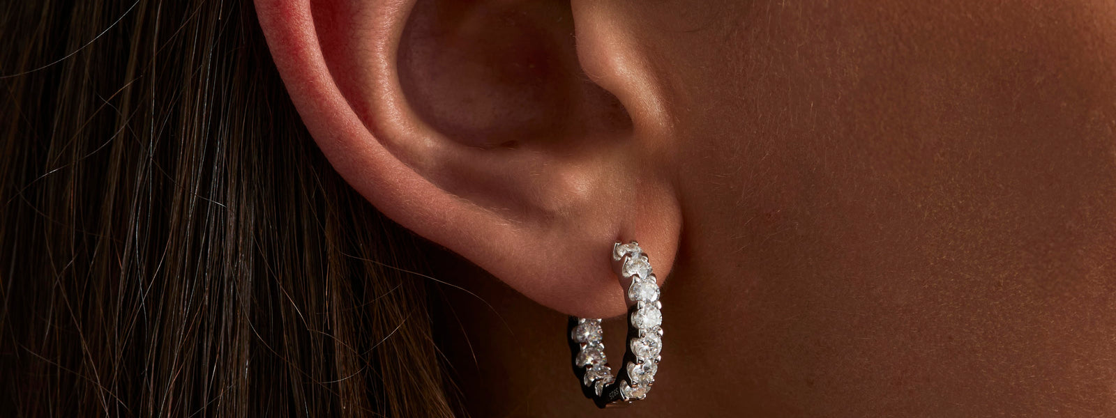 Moissanite hoop earring worn on the ear