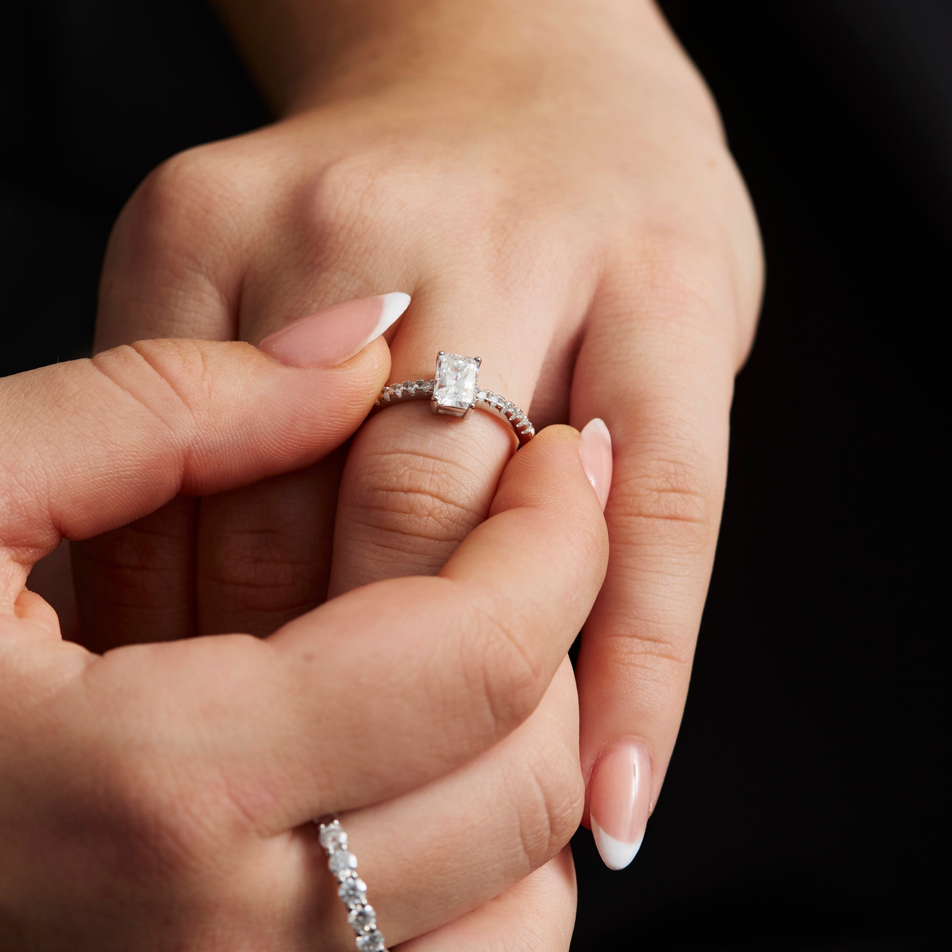 Moissanite ring held between fingers