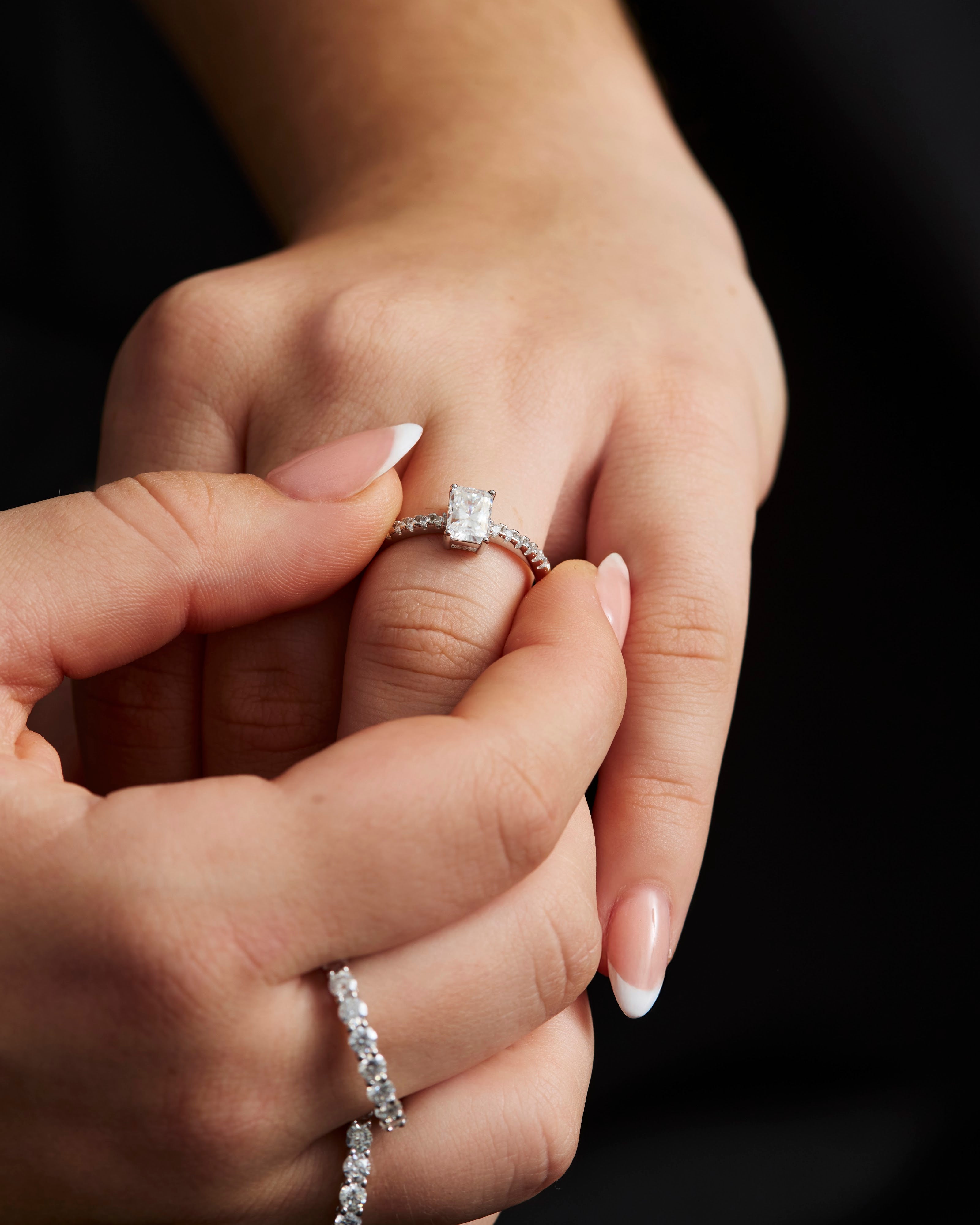 Moissanite ring held between fingers