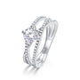 Solitaire moissanite cross band ring with pavé shoulders in sterling silver.