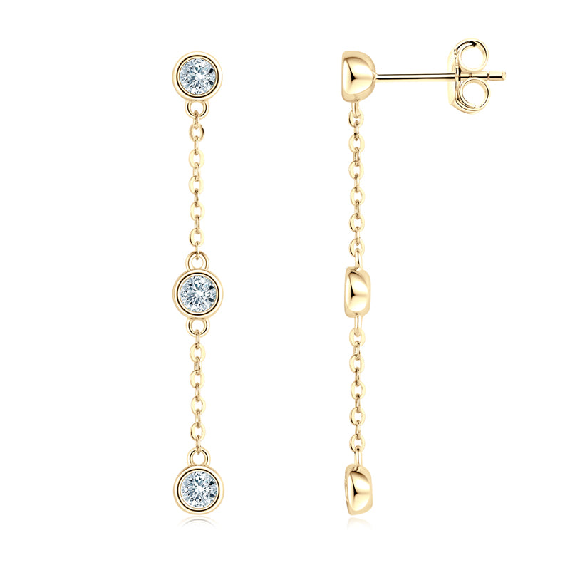 Gold earrings with three small diamonds on a white background