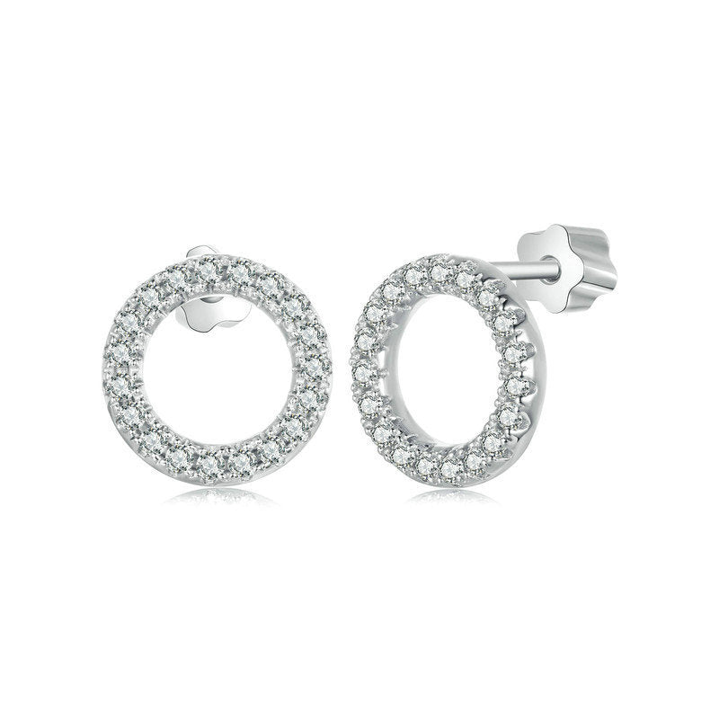 Pair of silver stud earrings in a circle of pavé moissanites on a white background