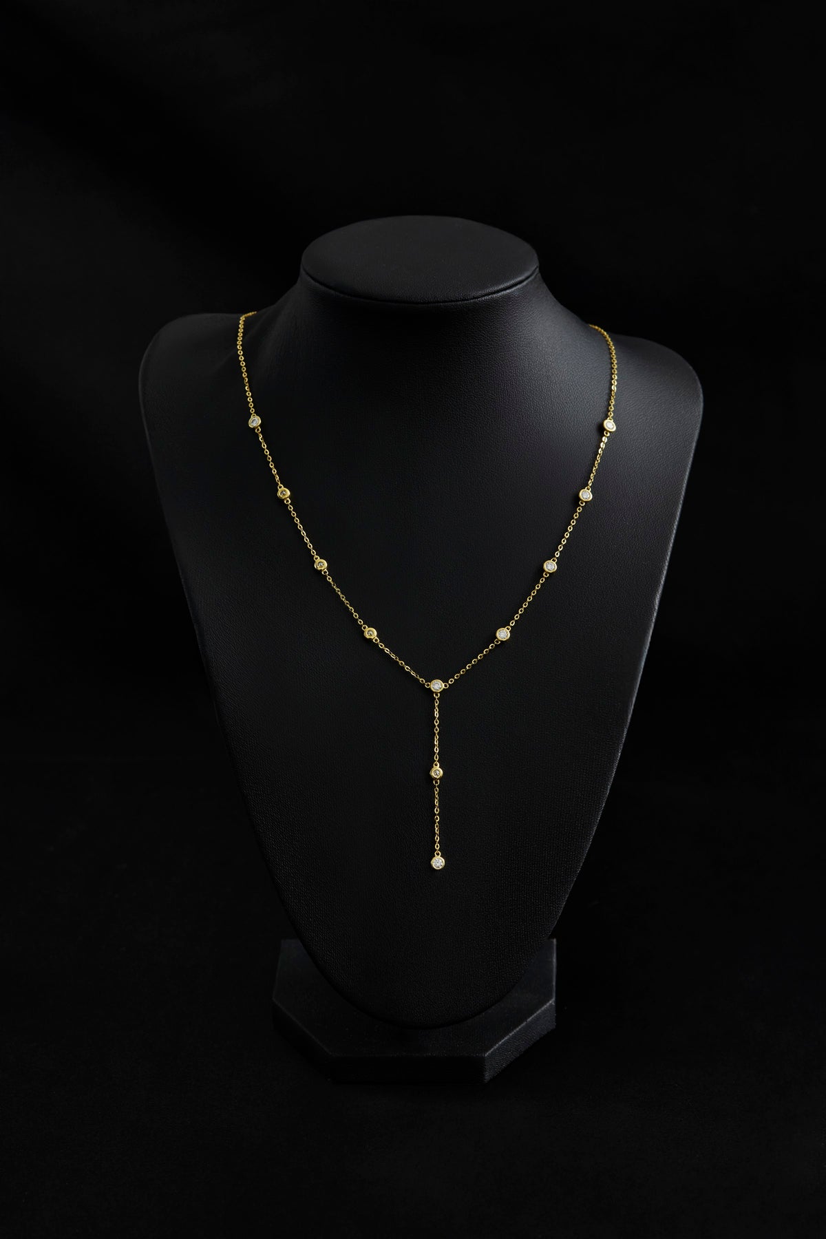 Lumiere Bezel Y Necklace in gold on a display bust