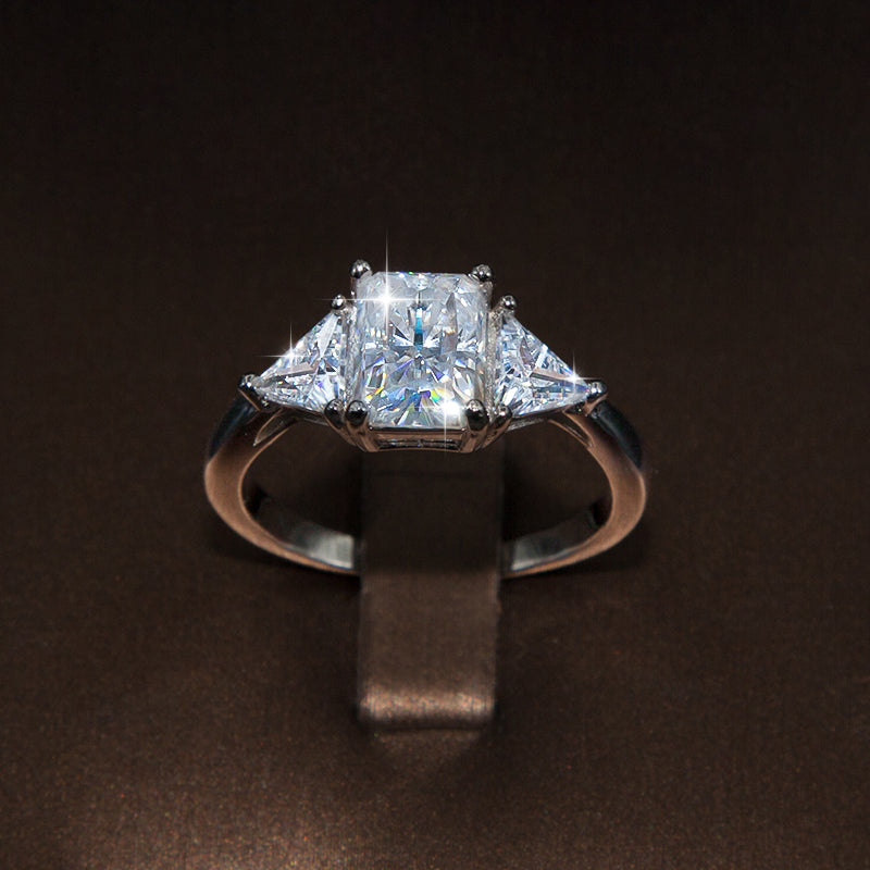 Noémie Radiant cut moissanite ring with Triangle side stones in ring holder brown leather
