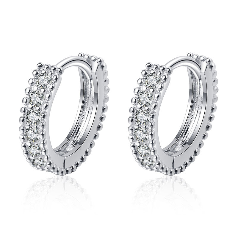 Silver hoop earrings with clear gemstones on a white background