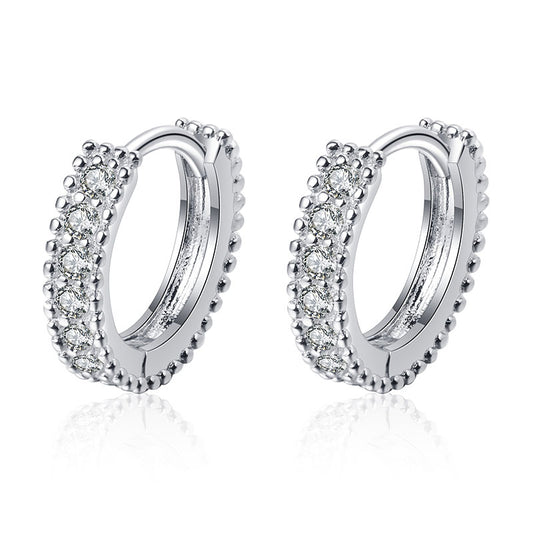 Silver hoop earrings with clear gemstones on a white background