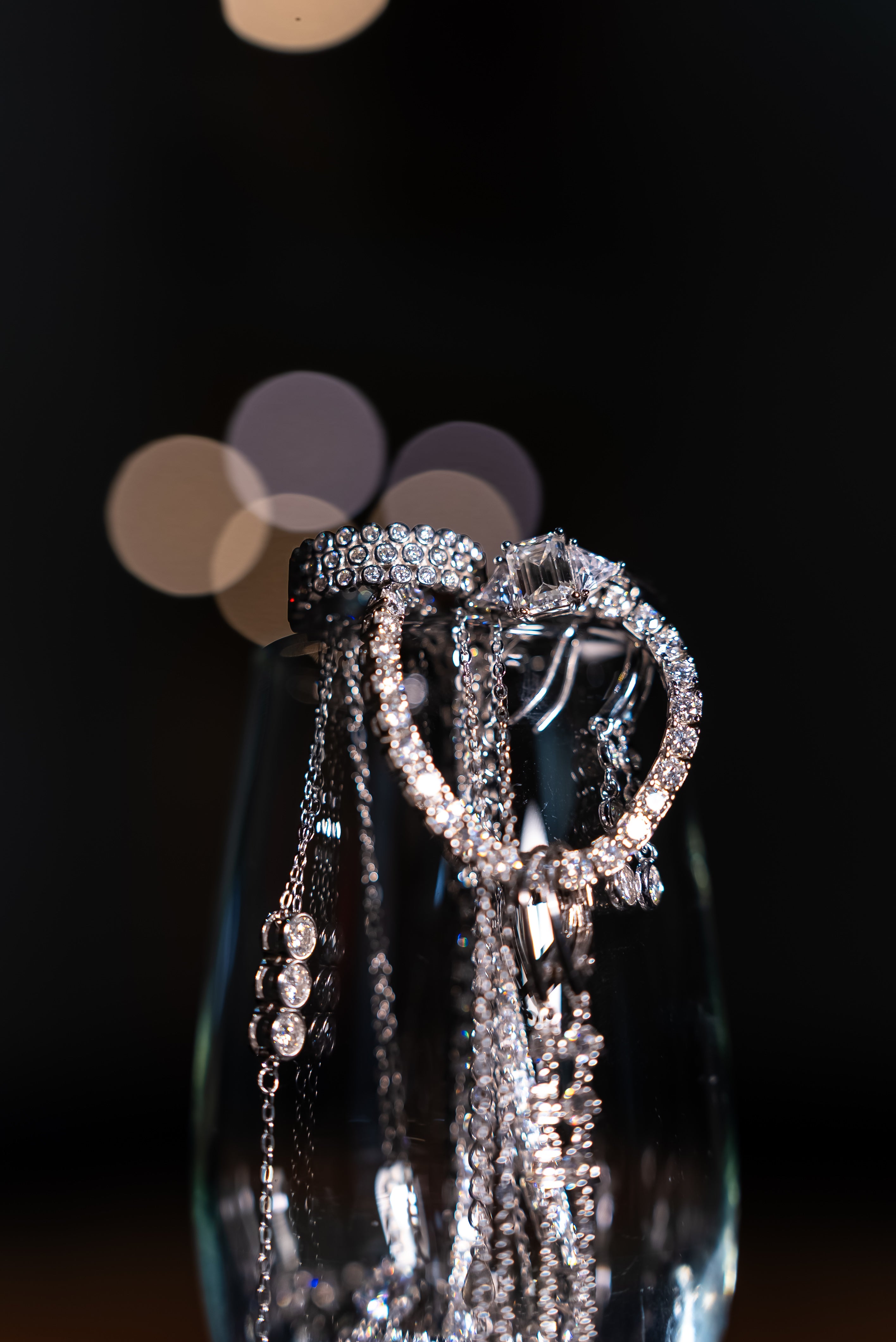 Moissanite jewellery draped over a champagne glass