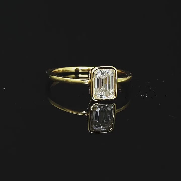 Hannah Emerald Cut Bezel Solitaire Side in video black shiny background